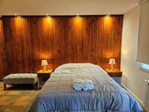 een slaapkamer met een bed met twee handdoeken erop bij Del Cerro Departamentos x 4 in El Calafate