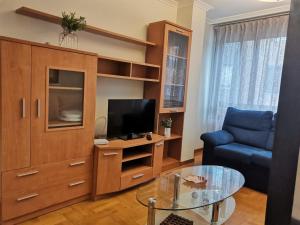 a living room with a tv and a couch and a table at Apartamento Llanes Mar y Monte in Llanes