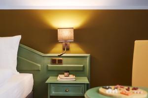 ein Schlafzimmer mit einem Bett und einem Tisch mit einer Lampe in der Unterkunft TUI SUNEO Kinderresort Usedom in Trassenheide