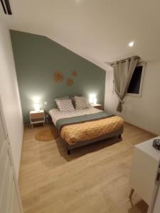 a bedroom with a bed with two lamps on it at Cottage neuf - Forêt de Tronçais in Urçay