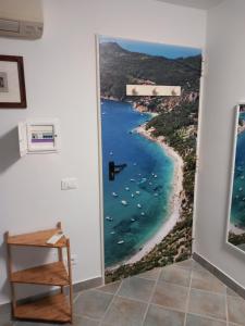 una porta aperta per una spiaggia con barche in acqua di Residence Sole Dell'Argentario a Porto Santo Stefano