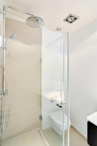 uma casa de banho com um chuveiro e um WC. em Spacious Flat Centrally Located in CPH's Old Town em Copenhague