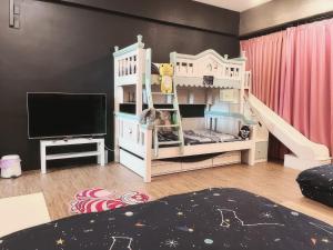 東港的住宿－前寓民宿，卧室配有白色双层床和电视。