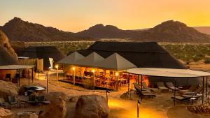 a safari tent in the desert at sunset at Twyfelfontein Adventure Camp in Khorixas