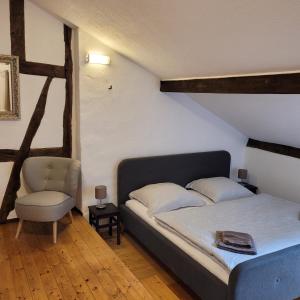 1 dormitorio con 1 cama y 1 silla en Alter Posthof Lieser, en Lieser