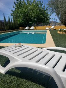 a white bench next to a swimming pool at Casa Los Bartolos in Vélez-Rubio