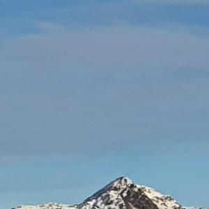 a snow covered mountain with a blue sky in the background at apartment porthmadog harbour side fantastic views in Porthmadog