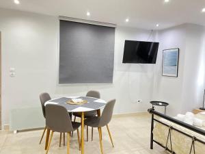 a dining room with a table and chairs and a screen at Varkiza House in Varkiza