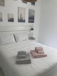 un letto bianco con due asciugamani sopra di Casa sul mare a Torre Canne