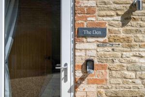 a sign on a brick wall next to a door at Fletland Mill and Holiday Hamlet - 18th century watermill, in stunning location near Stamford in Stamford