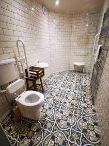 uma casa de banho com WC e piso em azulejo em Comrie Croft em Crieff