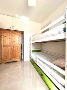 a room with two bunk beds and a wooden door at Appartement 2 chambres à Lama avec Piscine in Lama