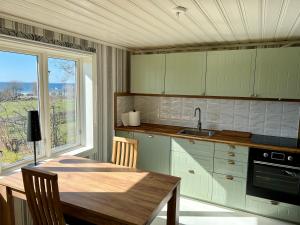 a kitchen with a wooden table and a window at Klinta sea view in Köpingsvik