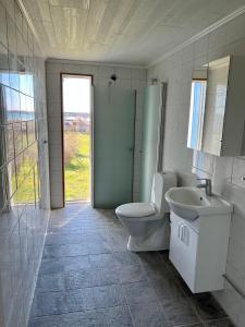 a white bathroom with a toilet and a sink at Klinta sea view in Köpingsvik
