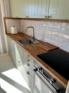 a kitchen with a sink and wooden counter top at Klinta sea view in Köpingsvik