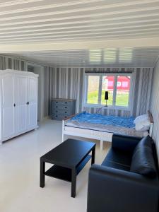 a bedroom with a bed and a couch and a table at Klinta sea view in Köpingsvik