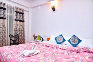um quarto com uma cama rosa com um cisne branco em Lava Hotel Aashiyana em Lava