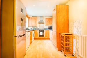 a kitchen with wooden cabinets and a refrigerator at Austin David Apartments - Hendon Pad in Hendon