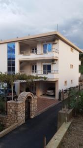 a large white house with a stone wall at AS Apartments in Ulcinj