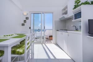 a white kitchen with a view of the ocean at Kate's Place in Dubrovnik