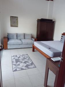 ein Wohnzimmer mit einem Sofa und einem Bett in der Unterkunft Villa Suyara Rooftop,,, in Panadura