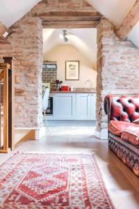 a living room with a couch and a kitchen at The Forge, Pillar Box Farm Cottages in Ludlow