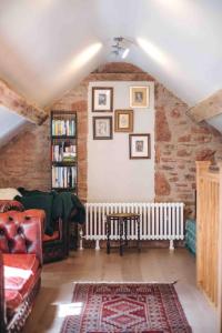 a living room with a couch and a book shelf at The Forge, Pillar Box Farm Cottages in Ludlow