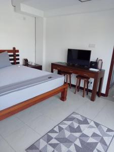 - une chambre avec un lit et un bureau avec un ordinateur dans l'établissement Villa Suyara Rooftop,,,, à Panadura