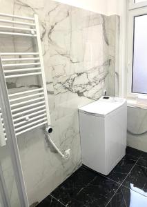 bagno con servizi igienici e parete in marmo. di skadarlija bohemian a Belgrado