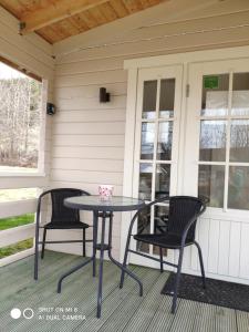 einen Terrassentisch und zwei Stühle auf einer Veranda in der Unterkunft Laugar Guesthouse in Laugar