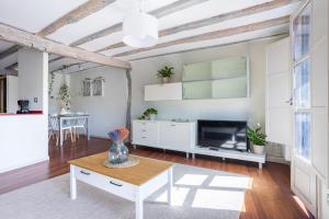 een woonkamer met een tafel en een tv bij IZARO BEST VIEW By Urdaibai Rentals in Bermeo +6 foto's