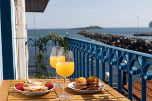 a table with two glasses of orange juice and food at IZARO Best View in Bermeo