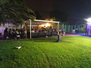 a group of people sitting in a park at night at Munach Guest Lodge in Benoni