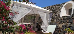 uma cortina branca no lado de um edifício com flores em La Palma em Pantelleria