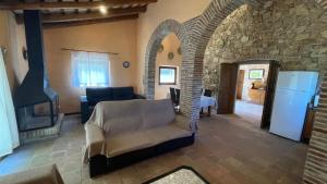 ein Wohnzimmer mit einem Kamin und ein Wohnzimmer mit einer Steinmauer in der Unterkunft AMAZING Typical House with Swimming Pool in Sant Feliu de Guixols