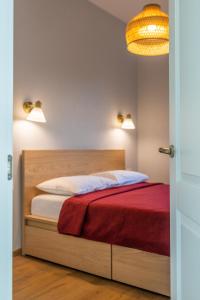 una camera con un letto con una coperta rossa di GENIO 7 apartamentai a Palanga