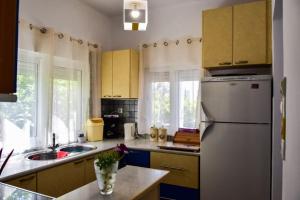 a kitchen with yellow cabinets and a refrigerator at Μονοκατοικία δίπλα στην Θάλασσα in Salamís