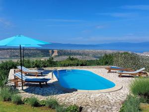 a swimming pool with two chairs and an umbrella at Villa Mery in Šmrika