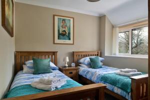 two beds in a room with towels on them at Finest Retreats - Felin Ship in Dolgellau