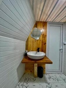 ein Badezimmer mit einem Waschbecken auf einer Holztheke in der Unterkunft Bali Glamping in Ambrolauri