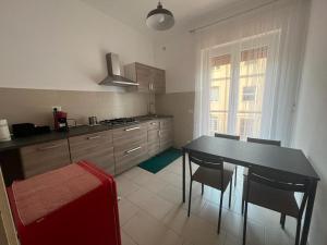 a kitchen with a table and chairs and a window at Kannur in Ladispoli