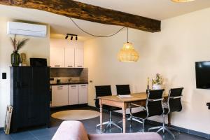 una cucina e una sala da pranzo con tavolo e sedie di Hoeve de Reetjens - La Porcherie a Bilzen