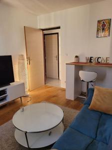 een woonkamer met een blauwe bank en een tafel bij Chaleureux 2 pièces proche de Paris & La Défense in Colombes