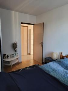 een slaapkamer met een bed en een deur naar een gang bij Chaleureux 2 pièces proche de Paris & La Défense in Colombes