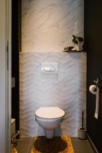 La salle de bains est pourvue de toilettes blanches. dans l'établissement Hoeve de Reetjens - La Porcherie, à Bilzen