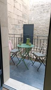 a green table and two chairs on a balcony at Dastro Logis in Saint-Rémy-de-Provence