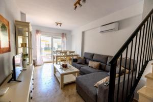 salon z kanapą i stołem w obiekcie Lightbooking Lago Alca w mieście Chipiona