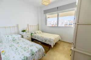 sypialnia z dwoma łóżkami i oknem w obiekcie Lightbooking Lago Alca w mieście Chipiona +6 zdjęć