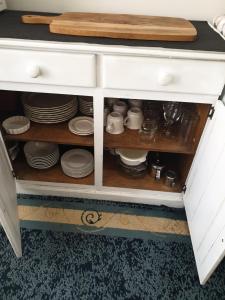 a white cabinet with plates and dishes in it at Telperio - Guest suite max 4 Guests in Bunbury