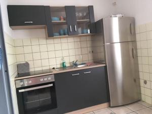a kitchen with a stainless steel refrigerator and cabinets at Ferienwohnung Schmäing, Haiger/Westerwald / Rothaarsteig in Haiger